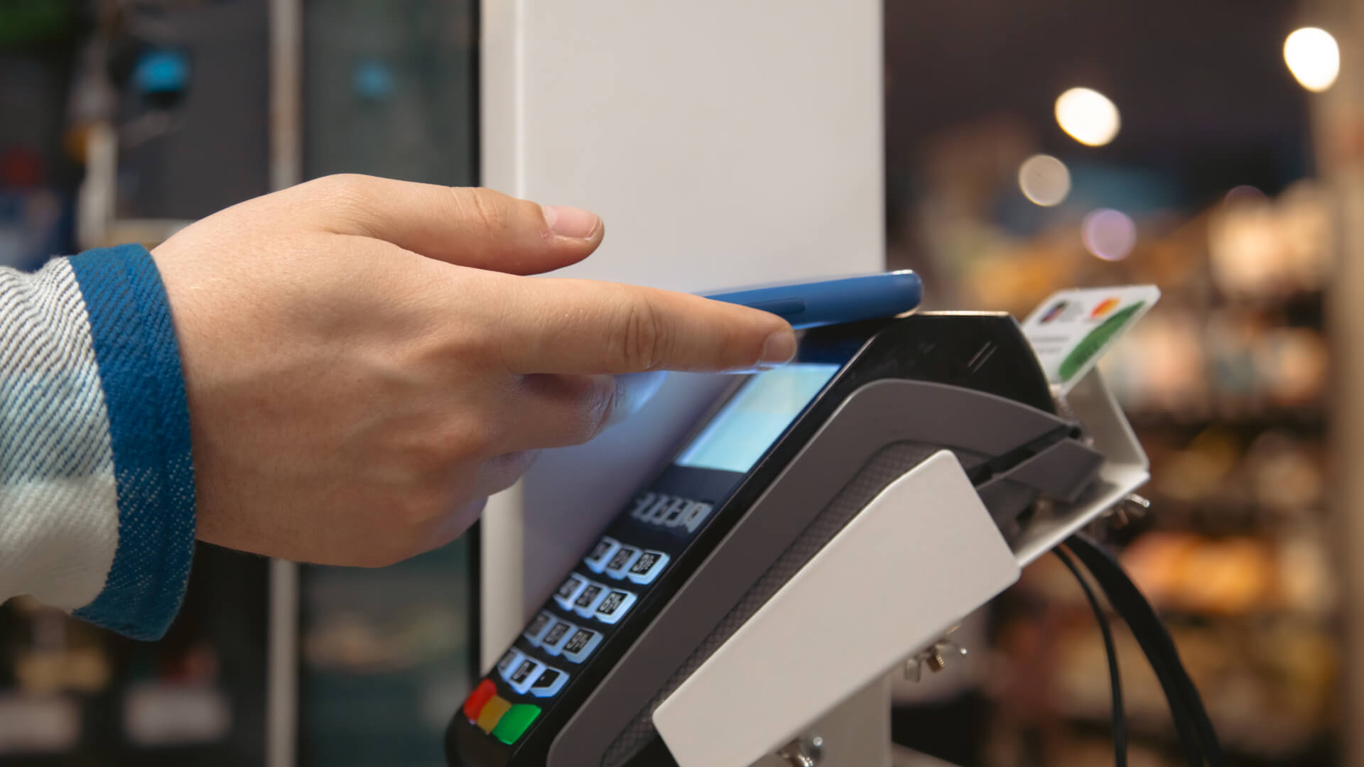 close-up-male-hand-holding-smartphone-payment-terminal